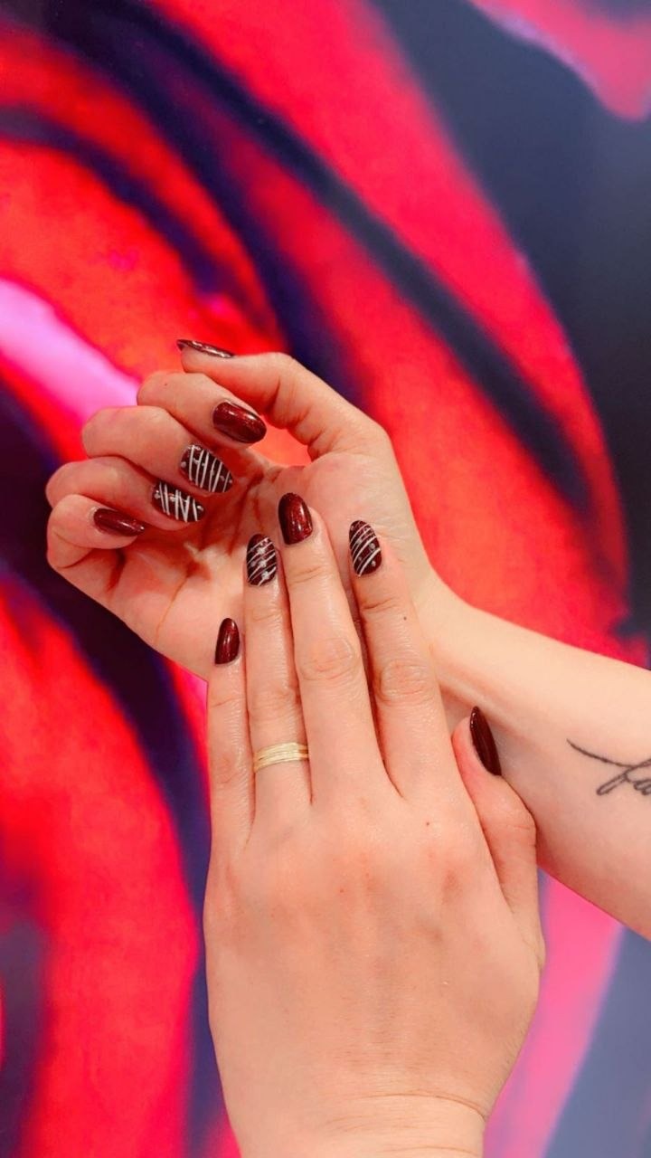 Burgundy nails with white stripe art at Kingdom of Beauty, Abu Dhabi