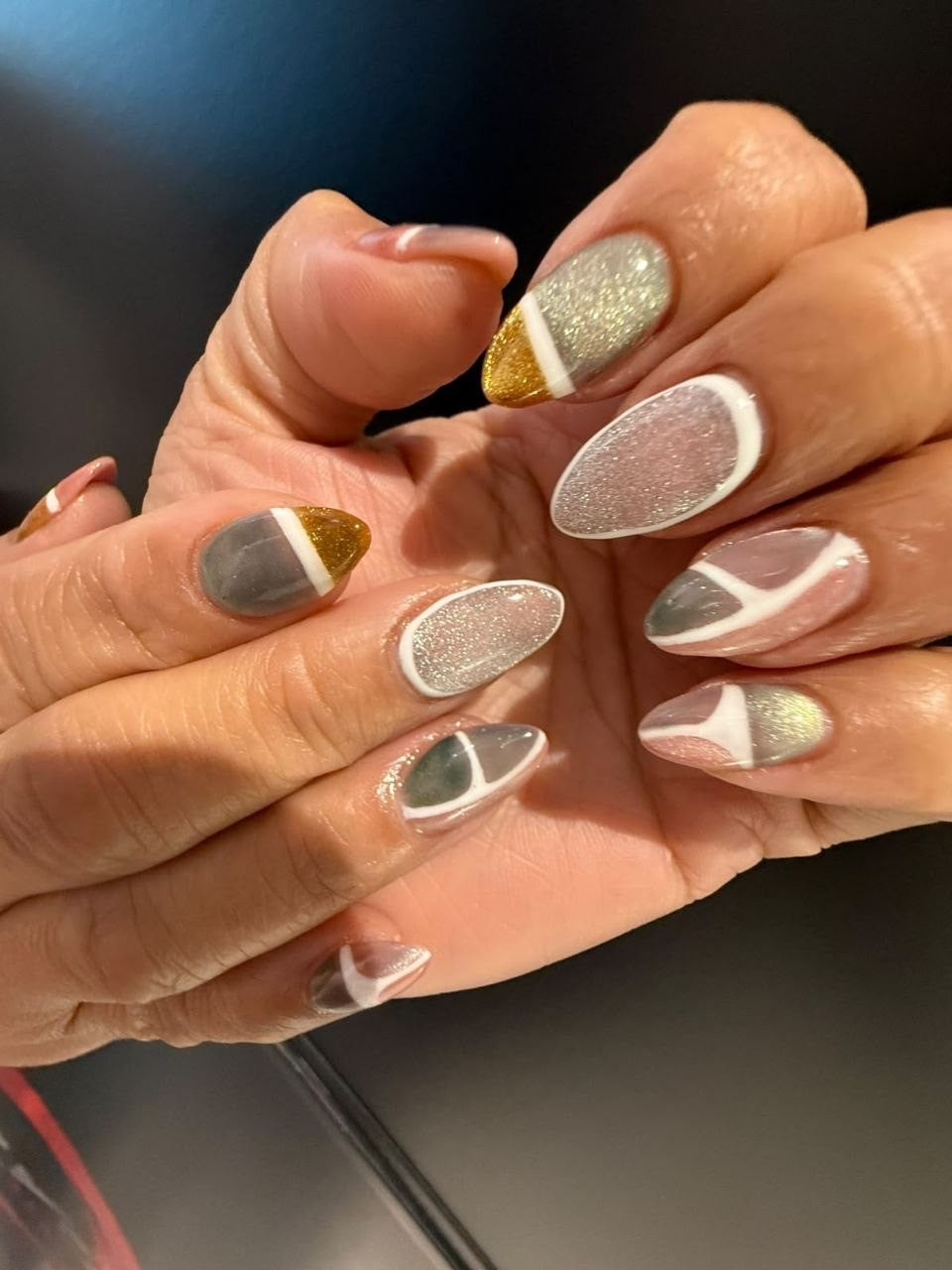 Cat-eye nail art with gold and white lines by Kingdom of Beauty, Abu Dhabi